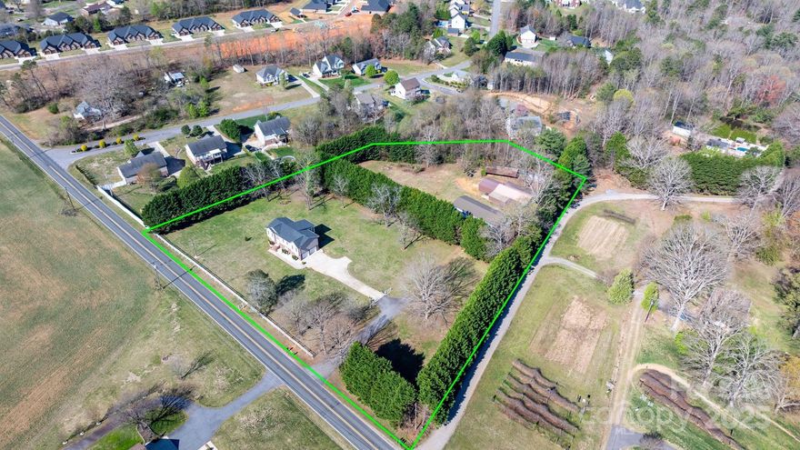 Nestled in the desirable St. Stephens community, this exceptional 3-bedroom, 3-bath home with finished basement and glass enclosed sun porch overlooking a treelined yard sits on 3.5+ acres, offering privacy, space, and endless potential. The property features a 1,345 sq. ft. 4-car garage/workshop and a 1,750 sq. ft. workshop/barn with a car lift, making it a dream for car enthusiasts, hobbyists, or anyone in need of extra workspace. A caretakers living quarters attached to the detached 4 car garage. The rear half of the property is tree-lined and fenced, providing a serene setting for outdoor activities, livestock, or future expansion with gated entrance from the side of the driveway. With its prime location and versatile amenities, this unique property is a rare find with endless possibilities—schedule your showing today!