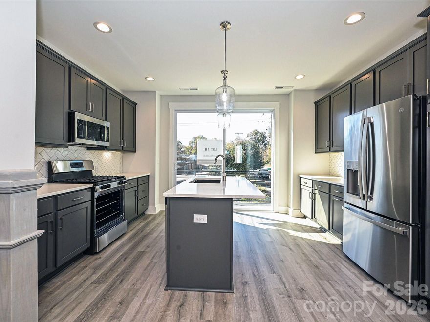 4-story townhome walking distance to restaurants in NoDa, with easy access to Plaza Midwood, and Uptown Charlotte just minutes away. 2-car tandem garage plus private driveway for additional parking. All kitchen & laundry appliances INCLUDED! Easily entertain in the 4th floor rec room w/ powder & rooftop terrace, or use the rec room as an additional guest bedroom or home office. Kitchen features 42" dark grey painted cabinets, quartz counters, LED under-cabinet lights, a large undermount stainless steel sink, pantry, & GE stainless steel appliances with gas range & fridge. Small balcony off the kitchen offers additional outdoor space. Both outdoor spaces have TREX decking. Nook by the second-floor stairs offers space for a desk. Laundry is located on the third floor. A stacked GE washer/dryer is included. Private Premier Bath has light grey painted cabinets, quartz counters, tiled floor, & a tiled shower. Guest bath features dark grey cabinets, quartz counter, tiled floor. Low-maintenance LVP flooring is throughout the 1st and 2nd floors plus 3rd floor hall, with oak treads on all stairs. 9' ceilings throughout.