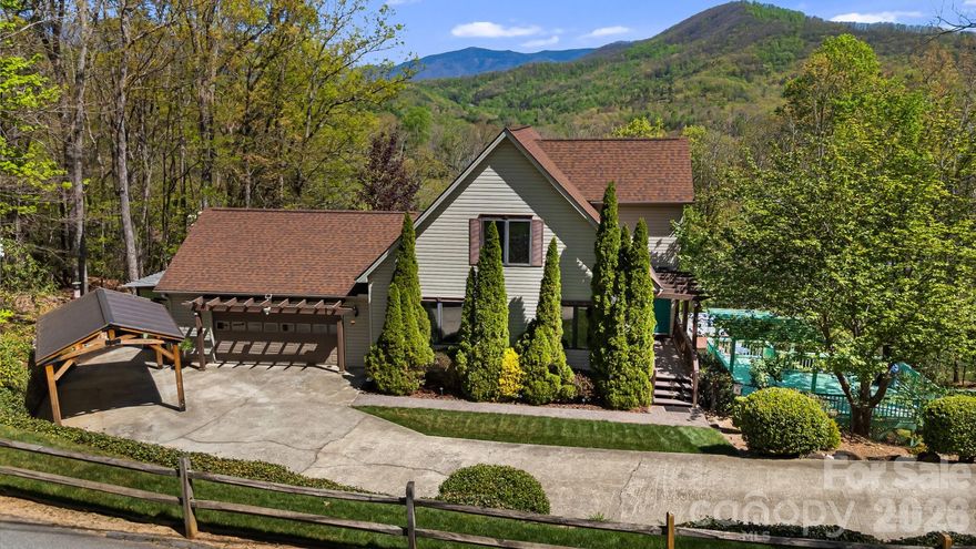 Perched above the fairways with sweeping long range mountain views, this stunning home offers the perfect blend of craftsmanship and mountain charm.  Soaring cathedral ceilings with expansive windows create a light-filled living space, beautifully accented by custom woodwork and detailed tile finishes.  The inviting stone fireplace serves as the heart of the home--ideal for cozy evenings.  The kitchen is open to the main living area making everyday living simple and entertaining easy.  Upstairs, the primary retreat provides privacy and relaxation including a large soaking tub and its own balcony nook.  The finished basement expands your living space with a family room and two extra bonus rooms that can be utilized for office space, recreation room, or guests; there's room for it all!  The two car garage comes equipped with a 50amp EV Charger installed. Additionally, there is a workshop and shed providing plenty of room for projects and storage.  Step outside and take in breathtaking vistas overlooking the golf course and Lake Tomahawk just beyond.  Whether you're enjoying morning coffee on one of the three deck spaces or entertaining guest at sunset the setting is nothing short of spectacular.  Located just minutes from the charm of downtown Black Mountain, this home offers both peaceful privacy and convenient access to local dining, shops, and outdoor recreation.  A true mountain escape with timeless finishes and unforgettable views.