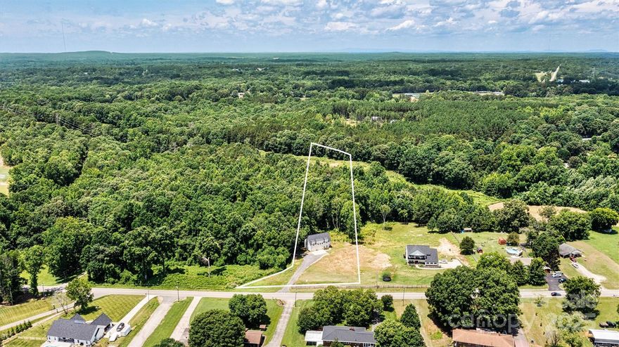 PRICE IMPROVEMENT! No restrictions—bring your vision to this versatile 3+ acre property in Stanley! Enjoy the best of both worlds w/a peaceful setting just minutes from Denver, convenient access to stores, & an easy commute to Charlotte. Much of the land is cleared for immediate use, while mature trees at the rear offer shade and privacy—perfect for domestic & farm animals alike. The home features open-concept main living, ideal for entertaining. LVP flooring runs throughout the living spaces, complemented by tiled bathrooms for style & practicality. Upstairs, the bright & inviting great room flows into the dining area & well-appointed kitchen w/granite countertops & a central island. Primary suite includes an ensuite bath, while the main level offers a flex space, office & half bath—giving you flexibility for work, hosting or relaxation. This property is a fantastic opportunity to build your forever home while earning rental income from the existing residence.