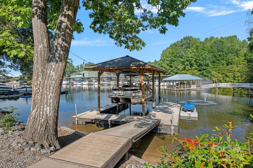 Price Reduction on this beautifully renovated Waterfront Ranch home in a deep water cove. Covered boat slip, 10,000 lb hoist.  5 CAR GARAGE SPACES! (2 in attached garage & 3 in DETACHED GARAGE + storage area & LED lighting) Extra garage could be converted to guest house or workshop! NO HOA!! Short term rentals allowed. Featuring a walkout basement this home has new wiring, plumbing, drywall, roof, windows, doors, siding, garage doors, kitchen, appliances, bathrooms, HVAC system, water heater, Gutter Guards & More! Kitchen & main living area has an accordion style glass door w/screen that opens to large deck with Trex composite decking which has been waterproofed underneath, providing an amazing outdoor living space on the lower level! 4 Bedrooms, 3 Full Bathrooms; + extra room for theatre, exercise or office.  Exceptional landscaping with Zoysia grass, lake fed sprinkler & drip system & landscape lighting, Easy sloped backyard leads to the boat dock.  Private electric gated entrance.