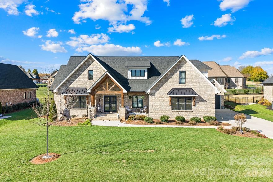 This is the kind of home that makes you slow down, take a breath, and picture your life unfolding inside. From the welcoming covered front porch to the soaring two-story great room, every space was designed with comfort, function, and flexibility in mind. The light-filled living area features a color-changing electric fireplace that creates instant ambiance for quiet nights or lively gatherings. The kitchen is truly the heart of the home—abundant counter space, towering stacker cabinets, a stunning painted island, and a farmhouse sink with filtered water make it as practical as it is beautiful. A generous walk-in pantry with custom shelving and a built-in planning desk keeps everything organized and within reach. The private owners’ retreat offers a spa-like escape with a soaking tub, separate walk-in shower, and an oversized closet that connects directly to the laundry room for everyday ease. The split-bedroom floor plan provides privacy, with two additional bedrooms and a full bath on the opposite wing. Upstairs, a massive bonus room with its own full bath gives you options—guest suite, media room, playroom, or additional bedroom. A main-level bedroom currently used as a library or office adds even more versatility. Enjoy evenings on the screened porch overlooking the fully fenced backyard, or relax on the covered front porch. With over 3,000 square feet, 3 bedrooms, 3.5 baths, and an impressive 877 square feet of garage space—including a spacious two-car garage plus a separate one-car bay with storage—this full-brick home offers room to live the way you want. Peaceful setting. Thoughtful design. Space to grow. Come see it in person—and decide if this is the one.