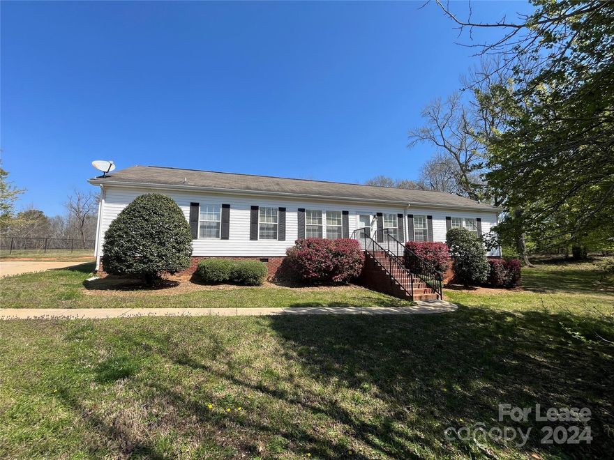 This awesome 3 bed, 2 bath, 2,100 sq. ft. ranch home in Indian Land, SC is just waiting for you!  Beautiful wood laminate flooring, crown molding and a ceiling fan adorn the spacious, sunlit living room. The large eat-in kitchen shares a breakfast bar with the dining area and includes a white appliance package and pantry. Your primary bedroom features a long walk-in closet and an en suite bath with an extended vanity, garden tub and separate shower. Two additional bedrooms share a second full bath. Ceramic tile and Stainmaster carpet throughout the home. Sliding doors open to a patio in the huge tree-lined back yard, perfect for cookouts! Lawn care is included.  Gas heat and central air.