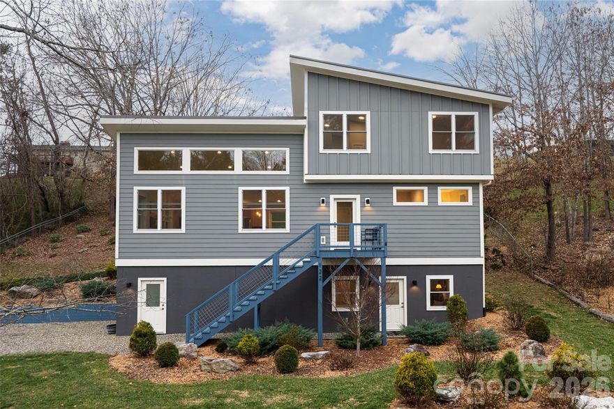 Energy-efficient custom home built in 2020 located in a sought-after Weaverville neighborhood with mature trees and large lots. This modern mountain home features an open floor plan with vaulted ceilings, wood floors throughout, and expansive windows that fill the home with natural light.

Main-level living includes a gourmet kitchen with stainless steel appliances, center island seating, and generous prep space—ideal for entertaining. The primary bedroom suite on the main level offers a spa-style bathroom with double vanity, tile floors, walk-in shower, and large walk-in closet with natural light.

The upper level provides two additional bedrooms, a full bathroom, and a flexible loft-style office with vaulted ceilings—perfect for remote work or guest accommodations. The lower level adds exceptional versatility with a private exterior entrance, full bathroom, and space suitable for a guest suite, home office, gym, art studio, or secondary living area. A 1.5-car garage offers ample storage and workshop space.

Enjoy outdoor living on the large open deck with backyard access. Additional features include a metal roof, three-zone HVAC system, and meticulously maintained interior. Convenient location just minutes to Downtown Weaverville, shopping, dining, and approximately 15 minutes to Downtown Asheville and the Blue Ridge Parkway.