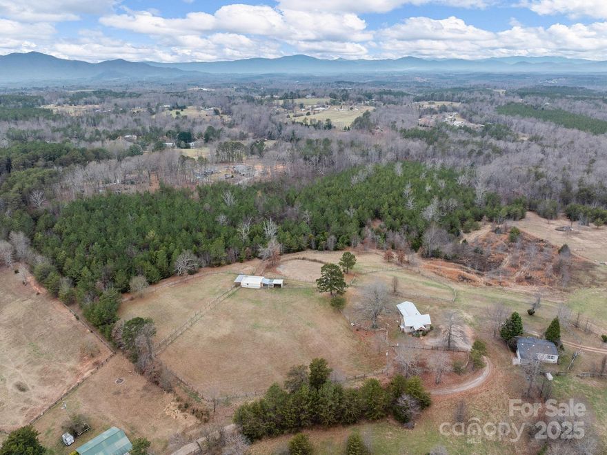 Panoramic Mountain Views on this 11.25 acre property with a charming rustic 1 bedroom/1 bath cabin, a 3-stall barn with a run-in shed, additional storage shed within minutes of Tryon International Equestrian Center.  The four-split rail fenced pastures have easy access to the barn and riding ring with access to equestrian riding/walking trails. Cabin has an individual well, septic tank and electric meter. Also available but not included is an adjacent 3-bedroom/2-bath manufactured home on 3.46 acres with similar unobstructed Panoramic Mountain Views, a barn and fenced in area with its on well, septic tank and electric meter.