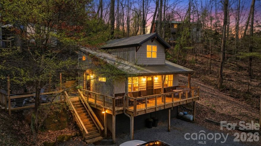 Exceptional turnkey investment opportunity featuring a dual-cabin estate on 0.42 acres, perfectly positioned for high-yield, short-term rental performance or a sophisticated private compound. 26 Yodelers Holler is a 2BR/1BA mountain retreat boasting vaulted ceilings, a remote-controlled fireplace, and a gourmet kitchen with butcherblock countertops, complemented by a private hot tub and fire pit area. Adjacent, 30 Yodelers Holler is a romantic 1BR/1BA carriage house offering a bespoke balcony bar, upscale kitchenette, and a secluded fenced-in hot tub sanctuary. Both residences feature paved access and a proven track record of significant year-round revenue. Located just 5 minutes from the shops and dining of downtown Bryson City and the Great Smoky Mountains Railroad, and within 15 minutes of the Nantahala Outdoor Center and Great Smoky Mountains National Park, this estate attracts premium occupancy from luxury travelers and outdoor enthusiasts alike. This lucrative portfolio addition offers unparalleled flexibility and high-end mountain living in a prime location.