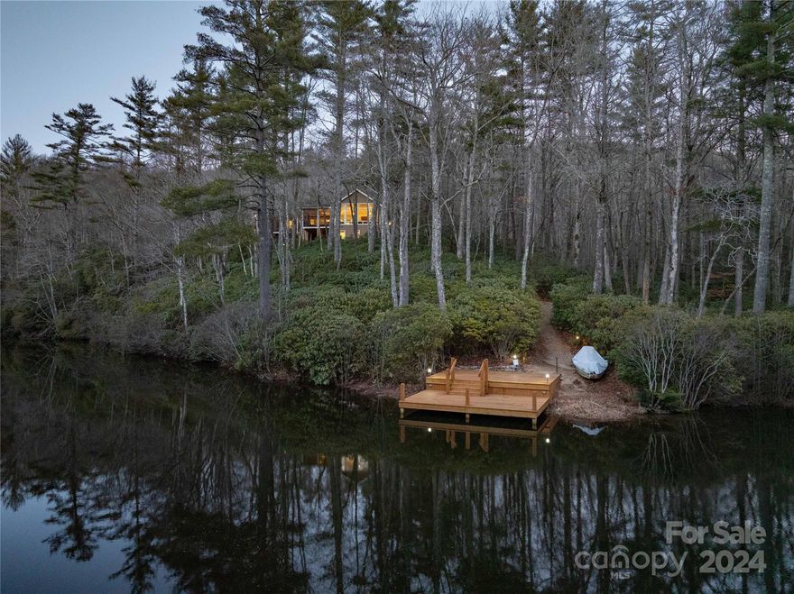 The possibilities are endless with this unique private retreat in Lake Toxaway Estates. Two lots combine to create a 5.2-acre oasis for nature lovers, with frontage on Lake Cardinal and Cardinal Creek. The meticulously crafted two-bedroom, three-bedroom home boasts an additional bonus space with a separate entrance, perfect for a guest suite, art studio, or home office. Enjoy your view of the lake from the screened porch, surrounded by lush landscaping, or follow one of the trails down to the dock and swimming area to take in the vista of Panthertail Mountain. A classic brick fireplace and oversized picture windows create an inviting living space. Outdoor enthusiasts will appreciate the nearby Toxaway River Trail, the entrance to Panthertown Valley, and Raven Rock Falls, just a short hike from home. The Lake Toxaway Country Club, Marina, and Greystone Inn are just minutes away by car. Seize this incredible opportunity to make your dreams a reality.