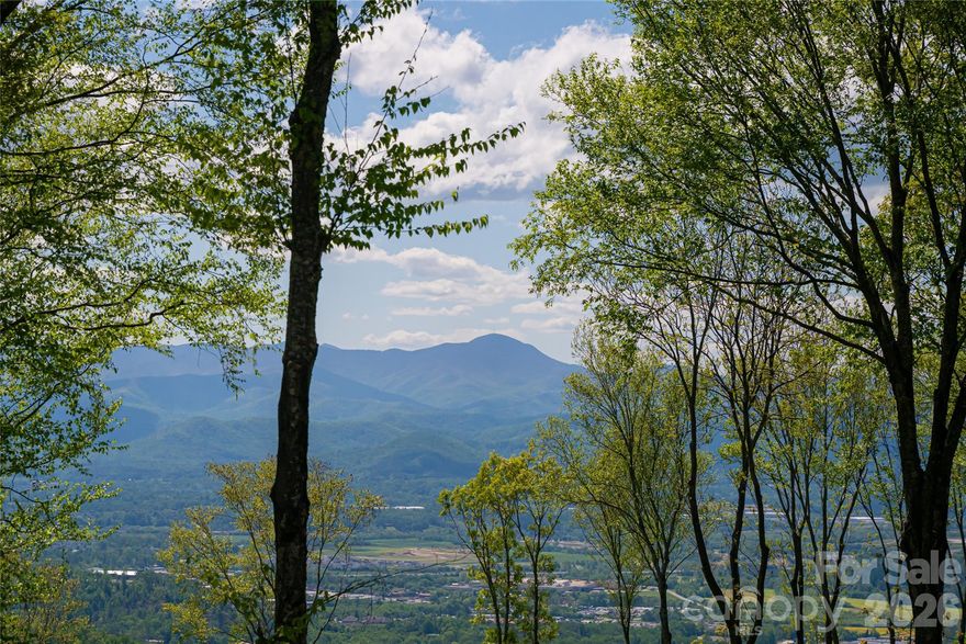 Perched at the top of Couch Mountain, with full 180-degree mountain views, this exceptional 2.88-acre homesite presents a rare opportunity to create a private mountain retreat where nature and design harmonize effortlessly. Unlike most summit parcels, this property offers the uncommon gift of gentle topography, an inviting canvas for your architectural vision. Here, dramatic boulder formations rise from the landscape, grounding the site in strength and permanence while framing sweeping, long-range mountain views that shift with the light and seasons. The homesite’s position at the summit ensures privacy and breathtaking panoramas, while its flat contours allow for ease of construction, outdoor living spaces and gardens that would be impossible on steeper terrain. For those seeking an expanded estate, the adjacent home and lot are also available, offering the potential to create a legacy property at one of Couch Mountain’s desirable vantage points. Couch Mountain itself is a gated conservation community unlike any other, encompassing 395 acres of preserved forest and just 81 thoughtfully placed homesites. This is a place where stewardship of the land is woven into daily life, where peace and privacy coexist with opportunities for connection. Residents enjoy miles of wooded recreational trails that wind through undisturbed forest, as well as two thriving community gardens that invite the joy of cultivation and sharing. With a mission rooted in wellness, sustainability and environmental preservation, Couch Mountain embodies a lifestyle that is as responsible as it is rewarding. This mountaintop property is conveniently 15 minutes from the Asheville Airport, and halfway in between Asheville and Hendersonville for quick and easy access to both communities. With community allowed seven-day rentals, this home is ideal for a lock-and-leave lifestyle with opportunities for potential income when not in use. It is a rare chance to craft not just a home but a legacy, an estate where serenity, connection and possibility converge atop the mountain. This is more than land. It is an invitation to create a life elevated, rooted in nature and inspired by the beauty of the Blue Ridge.