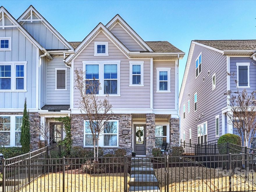 A privately gated front yard welcomes you with a picturesque front porch and beautifully maintained landscaping.  Inside, you enter to a spacious bonus room on the lower level - perfect as a secondary living area, home office, or playroom. A generously sized secondary bedroom features like-new carpet and ample closet space. The lower level full bathroom includes a tub and vanity, offering comfort and convenience for guests. 

Upstairs, the open-concept floor plan is designed for effortless living and seamless entertaining. The bright white kitchen showcases granite countertops, a warm gray subway tile backsplash, stainless steel appliances including a hood vent and gas cooktop, a built-in microwave, and stylish pendant lighting.

The spacious primary suite features a tray ceiling with recessed lighting for an elegant touch. The luxurious primary bath offers a large walk-in shower with glass door and gray tile, a dual vanity with granite countertops, and access to an incredible walk-in closet.

The two-car garage is equipped with an EV charger, and a mudroom with built-in lockers adds everyday functionality. Additional highlights include recessed lighting, custom window treatments, multiple storage closets and refreshed paint throughout.