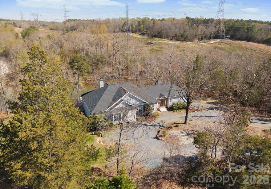 Indulge in the privacy and prestige of lakefront living on 4.4 acres with over 500 feet of shoreline along Lake Wylie. Tucked away in a serene, natural setting, this exceptional property offers a rare combination of expansive acreage, tranquil water views, and refined rustic elegance. Inside, the home is rich in character, featuring 5 bedrooms, 3 full bathrooms, heart pine floors and striking exposed pine beams that create a warm yet sophisticated ambiance. The seller's expanded in 2022 with the addition of two additional bedrooms, a versatile flex space, and a full bath—providing expanded accommodations ideal for guests, work-from-home living, or multi-generational needs. The primary suite is a private retreat, complete with tray ceilings and direct access to an expansive deck that spans the length of the home, seamlessly blending indoor and outdoor living. A screened porch offers a peaceful vantage point to enjoy quiet cove views and the surrounding wildlife. The walk-out lower level presents the perfect space for recreation or relaxation, while a  trail leads to your private floating dock—an idyllic setting for lakeside enjoyment.