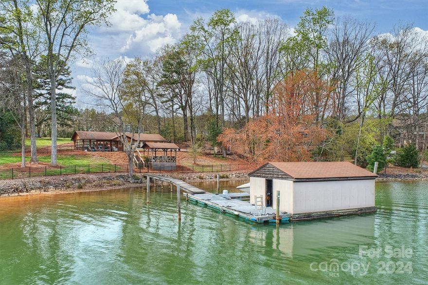 Fabulous waterfront property in PRIME NO HOA location surrounded by The Point! Privacy, beauty, no restrictions, low cost of ownership and one of the most desirable streets in Mooresville. This sweet cabin is the perfect weekender or building site for your dream home on Lake Norman. Gorgeous lot gradually slopes to lake with approximately 168 feet of shoreline on a large deep water cove with glorious lake views, private dock, rare boat house and stable shoreline. Enjoy the beauty of being on a large water cove that is safe for your boat and play, yet just a minute out to the main channel. Bring your own builder anytime or enjoy the existing cabin for years to come! Surrounded by newer custom construction and estate homes, this gorgeous property offers so many possibilities. Tremendous investment and potential for greatness. Do not miss the opportunity to own your slice of lakefront heaven on Lake Norman!