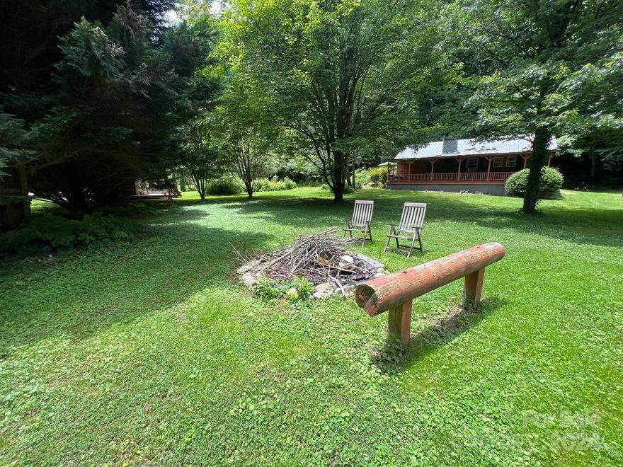 Welcome to "Walnut Bottom" a 4.5 acre retreat located along Wilsons Creek on the front of the property and Pisgah National Forest at the back of the property that is comprised of more than 500,000 acres. This could possibly be once in a lifetime opportunity to own approximately 168 feet of property along Wilson Creek, some of the best trout 
fishing in NC. The main house has two BR and one BA with an open floor plan with a large river rock fireplace and LARGE windows on the side of the home overlooking a creek with a small waterfall directly behind the house. There is a path behind the home that ascends up the hill following the creek (be careful it is slick). The detached garage
has a one bedroom studio apartment upstairs, with a private deck overlooking the woods. The yard has lots of fruit trees, Walnut, Chestnut, Etc.  Along the river you have a campsite with a deck, a screened room and a great access point to enter the river. A few words does not do this property justice.