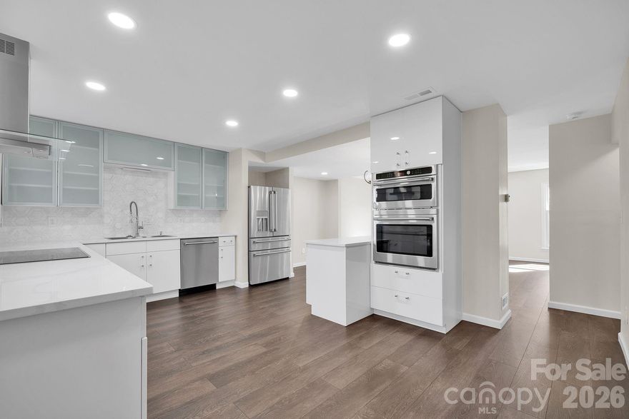 Beautifully renovated full brick front exterior townhouse with fully permitted upgrades completed in 2023–2024. The main living level was reconfigured to create a spacious open-plan kitchen and living area, including relocation of the powder room to maximize flow and openness. The custom kitchen features imported Italian marble tile with Mother-of-Pearl accents, European-style soft-close cabinetry with frosted glass upper cabinets, and Calacatta Gold granite countertops offering nearly 32 square feet of prep and bar space. Premium GE Café appliances include a ceramic cooktop, double oven (with combination microwave), and a French-style five-door refrigerator with ceramic LED backlit interior wall. Luxury waterproof wide-plank vinyl flooring runs throughout the home. Electrical upgrades include replacement of the exterior panel and water heater in 2018, interior panel replacement in 2023, and extensive electrical updates completed in 2023–2024. Much of the plumbing was also replaced during renovations. Upstairs, the primary bedroom closet was expanded to create a walk-in layout. Both the en-suite and family bathrooms were fully renovated with modern floating vanities, and the en-suite features a new LED lighted mirror with touchscreen controls. The basement powder room was enlarged to include a fully tiled 6’ x 6’ walk-in shower with dual rain shower heads. The basement also offers a new electric fireplace insert and a Murphy bed, allowing the space to function as either a guest room or additional living area. Outside, the enclosed private patio includes a wood-burning chimney fireplace. All certified renovation and structural modification plans are available for inspection.