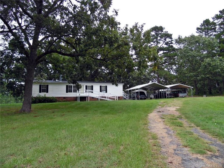 Privacy and country quiet await in this 3 bedroom, 2 bathroom home located on appx 4.9 acres!  Spacious kitchen with work island and generous cabinet storage opens up to dining area and family room with cozy fireplace.  Large master bedroom has master bath with separate tub and shower.  Huge patio perfect for grilling, plus a detached wired workshop with 1-car garage bay plus two carports and whole house generator.  An inviting home in such a peaceful setting!