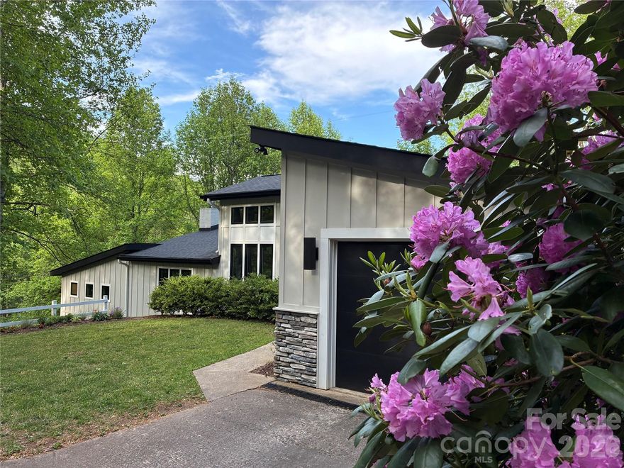 Tucked away in the highly sought-after Village of Forest Hills near Western Carolina University, this fully renovated mid-century modern retreat blends timeless contemporary design with the privacy and natural beauty of the mountains. Originally transformed in 2020, this one-of-a-kind architectural gem offers the rare combination of character, modern functionality, and an unbeatable location just minutes from campus, dining, and everyday conveniences. 

Welcome to this wow-factor 3 bedroom, 3 bathroom home with attached garage, an open-concept floor plan filled with natural light from oversized windows and thoughtfully designed spaces throughout. ­­ Hardwood flooring flows through the main living areas, while an elevated kitchen and dining space overlooks the room below, creating a striking, mezzanine-style ambiance that highlights the home's unique architecture. A gas fireplace brings warmth and ambiance to the living room, making the space feel both inviting and sophisticated. Designed for maximum privacy, each of the three bedrooms enjoys its own en-suite bathroom, offering unmatched flexibility for family and guests.

Outdoor living shines on the spacious back deck, the perfect vantage point for serene mountain evenings. Surrounded by mature landscaping and flowering shrubs, the property offers a peaceful, natural sanctuary. Enjoy a vibrant community feel without sacrificing the privacy of a mountain retreat. Whether you are walking or biking to campus, relaxing in nature, or entertaining friends on the deck, this home captures the ideal blend of contemporary mountain living and convenience. Don't miss this rare Forest Hills opportunity for timeless style and modern comfort.