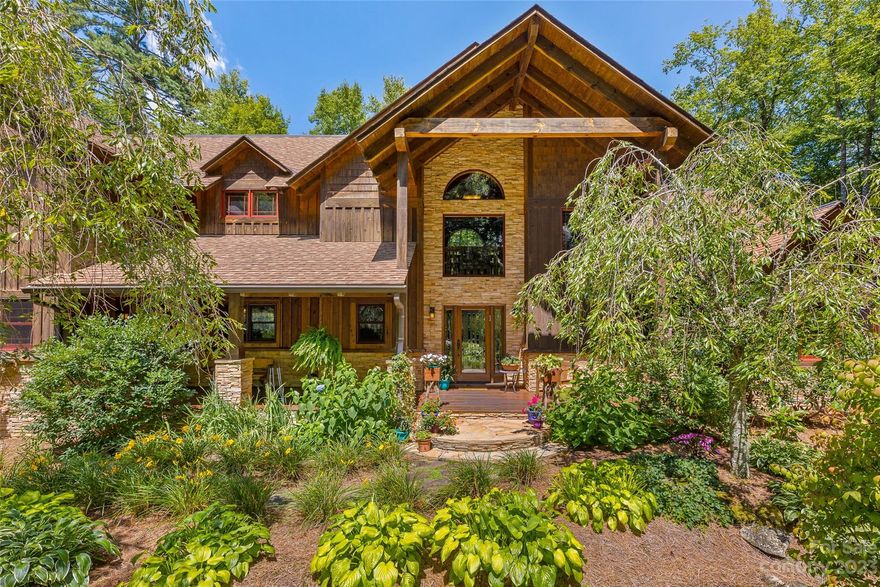 Welcome to your private mountain oasis! This exceptional gated custom home sits on nearly 12 acres, offering unparalleled luxury and craftsmanship. Every detail is attended to, from heart pine flooring to cathedral ceilings, enhancing the mountain experience. Gated driveway, lush landscapes, and spacious garage. Open living area, floor-to-ceiling fireplace, warm heart pine accents. Main level owner's suite with fireplace, cathedral-beamed ceilings, and opulent bath. The kitchen's copper accents flow into generous dining. Upstairs, a custom copper bar complements the bonus/media room. Step onto the deck to enjoy mountain air and fireplace ambiance, with forest views and glimpses of Highlands Falls CC driving range. Private walking trails wind through your personal grotto. Offered furnished for seamless move-in. Secluded yet 5 minutes from Main Street Highlands, this retreat blends solitude with convenience. Own this exquisite custom home that embodies mountain living.