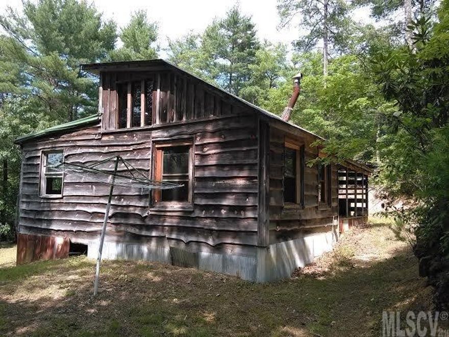 Unique 10 acre property was set up to operate off the grid. Panoramic Views, 2 streams with waterfalls, rugged Cabin, 385 foot deep well & 10 Acres:  antique kitchen gas stove, 40 gallon gas hot water heater & a gas refrigerator. A submersible deep well pump is in the well.  Energy efficient wood burner is the main source of heat - 2 small propane heaters are used for backup heat. Bathroom has jetted tub. North & West sides of the property are defined by Bear Pen Branch & Joe’s Fork Creek, including a triple waterfall. Streams include Native, Brook, Brown, and Rainbow Trout (4 types).  Located 30 minutes or less from attractions like Grandfather Mountain, ski slopes, Tweetsie Railroad, restaurants, Blue Ridge Parkway, University, Boone & Blowing Rock, shopping and more. Cabin is closer to Blowing Rock than Lenoir. Streams are hard to reach. No Permits-Sold AS IS, Owner will consider all offers. Land can be walked, stream sides are too steep to traverse. No Generator with property.