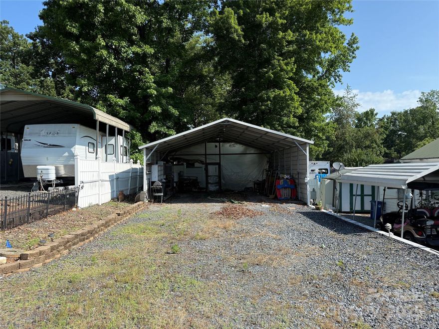 Empty level lot with metal carport. 24x26 with shelving. Lot has sewer and 100 amp power, does not have a water tap. Per the county, $1500 to add the water tap. The unit next door is for sale if you wanted 2 lots side by side. All clients have to be with realtor to gain entry to the community.