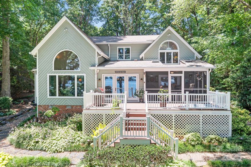 Welcome to your waterfront dream home on Lake Norman, offering expansive main channel views and stunning sunrises. On over an acre of beautifully landscaped property with mature trees, this home features a private covered dock with boat lift, PWC lift, and a covered lakeside seating area—perfect for enjoying peaceful lake days. Tucked away on quiet street shared by only 3 homes, the setting offers privacy and serenity. Inside, enjoy an open plan, water views from most rooms, including the primary suite. Plus, two additional bedrooms, bonus room, and a sunroom. Outdoor living is enhanced by the screened porch, grilling deck, & hot tub. Attached 2 car garage plus a 22x24 detached garage perfect for a boat, vintage car, or storage space. Just the perfect waterfront dream home!