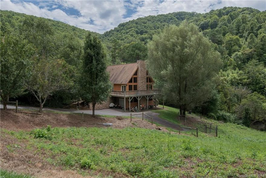 Breathtaking views, custom build with country charm everywhere you turn. Floor to ceiling windows and stone fire place will stop you in your tracks.  The 654 sq ft deck allows for outside living space.  Property also has a peaceful stream! Leave your cares behind in this peaceful retreat! Soaring vaulted ceilings and hardwoods on the main. Already plumbed room to expand in the basement.  Bring your horses and chickens! Short 15 minute drive to downtown Asheville. Don't let this one pass you by!