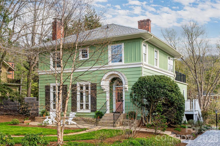 There is a warm, inviting grace to this Grove Park home that feels like a quiet sanctuary. It strikes a rare, beautiful balance: the character of a classic Asheville residence preserved with a refined aesthetic that feels both timeless and remarkably fresh. The defining characteristic here is the way the light follows you. Gracious, oversized windows are found in every room, acting as a primary design element that pulls the surrounding greenery into the living spaces. From the stunning foyer to the sophisticated living room, the home reveals itself as both significant and very approachable. The large dining room is scaled for gatherings, while the modern kitchen and open concept breakfast area offer a high-functioning hub for busy mornings. You even have the luxury of a dedicated laundry room, a modern necessity that is a total rarity for a home of this vintage. What truly distinguishes the property is how the multi-level addition has been seamlessly integrated into the original architecture. It doesn't feel like an afterthought; it feels like a natural evolution of the home’s footprint. The rooftop living space is an incredible open-air retreat perched among the treetops, offering a vantage point that is both peaceful and panoramic. Below, the garden-level second living room defies every "basement" cliché; with a full wall of windows looking out onto the grounds, it serves as a sun-drenched open space for recreation or a quiet home office. With five bedrooms and 3.5 baths, there is a sense of scale here that is hard to find. The detached garage, accessible via a convenient back alley, features an upper level perfect for a workshop or creative studio. 18 Edgemont isn’t just a well-maintained historic home; it is a property that has been loved forward, balancing the character of old Asheville with the light and flow of a modern lifestyle.