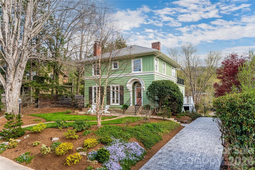There is a warm, inviting grace to this Grove Park home that feels like a quiet sanctuary. It strikes a rare, beautiful balance: the character of a classic Asheville residence preserved with a refined aesthetic that feels both timeless and remarkably fresh. The defining characteristic here is the way the light follows you. Gracious, oversized windows are found in every room, acting as a primary design element that pulls the surrounding greenery into the living spaces. From the stunning foyer to the sophisticated living room, the home reveals itself as both significant and very approachable. The large dining room is scaled for gatherings, while the modern kitchen and open concept breakfast area offer a high-functioning hub for busy mornings. You even have the luxury of a dedicated laundry room, a modern necessity that is a total rarity for a home of this vintage. What truly distinguishes the property is how the multi-level addition has been seamlessly integrated into the original architecture. It doesn't feel like an afterthought; it feels like a natural evolution of the home’s footprint. The rooftop living space is an incredible open-air retreat perched among the treetops, offering a vantage point that is both peaceful and panoramic. Below, the garden-level second living room defies every "basement" cliché; with a full wall of windows looking out onto the grounds, it serves as a sun-drenched open space for recreation or a quiet home office. With five bedrooms and 3.5 baths, there is a sense of scale here that is hard to find. The detached garage, accessible via a convenient back alley, features an upper level perfect for a workshop or creative studio. 18 Edgemont isn’t just a well-maintained historic home; it is a property that has been loved forward, balancing the character of old Asheville with the light and flow of a modern lifestyle.