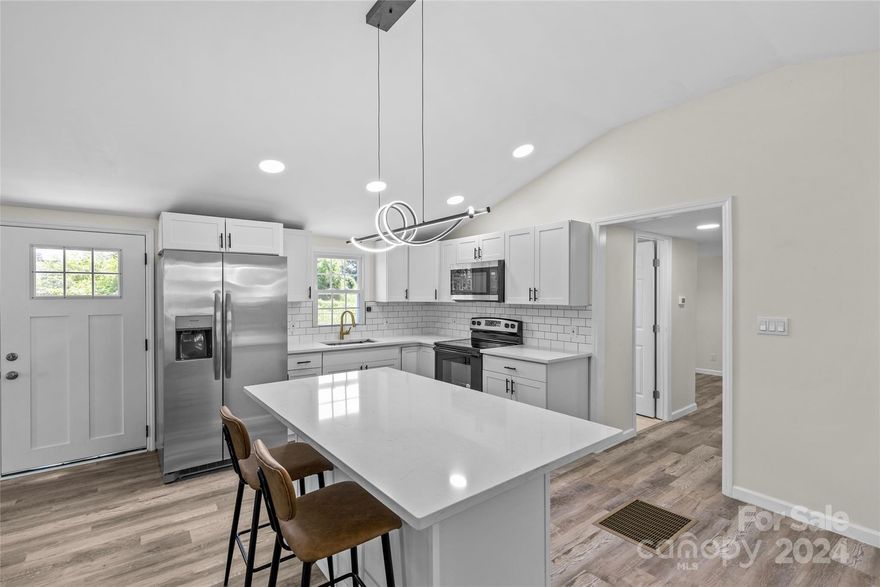 Welcome to this fully renovated 3BD, 1.5BA ranch in the heart of Gastonia! This charming home boasts 1,432 sqft of living space on a spacious 0.52-acre lot. Enjoy a seamless open floor plan with vaulted ceilings in the living room and kitchen. The custom kitchen is a chef's delight with stainless steel appliances and a large island perfect for entertaining. The home features all new windows, doors, and flooring throughout the house. The custom bathroom includes a stylish shower, and the large private backyard offers endless possibilities for outdoor activities. Close to all the shopping and retail Gastonia has to offer. Seller offers a 14-month home warranty and 100% financing is available. No HOA! Don’t miss out on this move-in-ready gem!