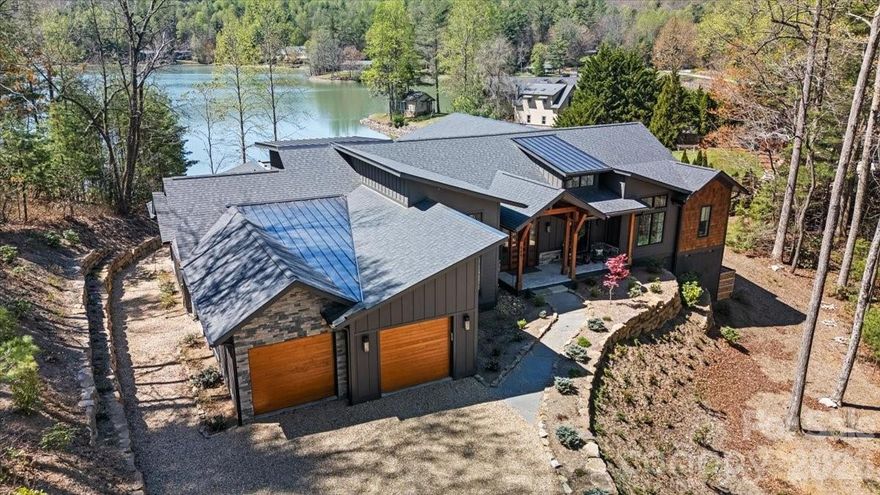 Panoramic lake and mountain views take center stage from this stunning property overlooking peaceful Eagle Lake. Designed to maximize the scenery, the home captures water views from nearly every room, blending modern lines with rich textures throughout. Enjoy cool mountain breezes from open decking with unobstructed sightlines, and step down to your private dock for easy access to trout- and bass-filled waters. Inside, a full chef’s kitchen anchors the home, while the primary suite offers a spa-like retreat with thermostat-controlled heated bathroom floors. Just minutes from Brevard, you’ll have access to hiking, biking, the Brevard Music Center, and the natural beauty of Pisgah National Forest and DuPont State Forest.