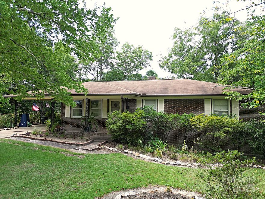 Well-maintained 3-bedroom, 1.5-bath brick ranch situated on a full acre with spacious front and back yards. From the front door, step into the formal living room. This move-in ready home features a kitchen with custom cabinets, a dining area with a cozy fireplace, and a large family room with built-in shelving and cabinetry—perfect for relaxing or entertaining. Hardwood floors run through most of the home, excluding the bedrooms, bathroom, and living room. A mudroom with laundry and a half bath adds everyday convenience. The primary bedroom is located near the full bath, with two additional bedrooms across the hall—one ideal for a home office or nursery. Enjoy the outdoors year-round from the heated and cooled sun-room, or unwind in the beautifully landscaped backyard beneath a mature pecan tree. The property also includes a a concrete driveway leading into a one-car carport, and two outbuildings that provide excellent storage and workspace options.