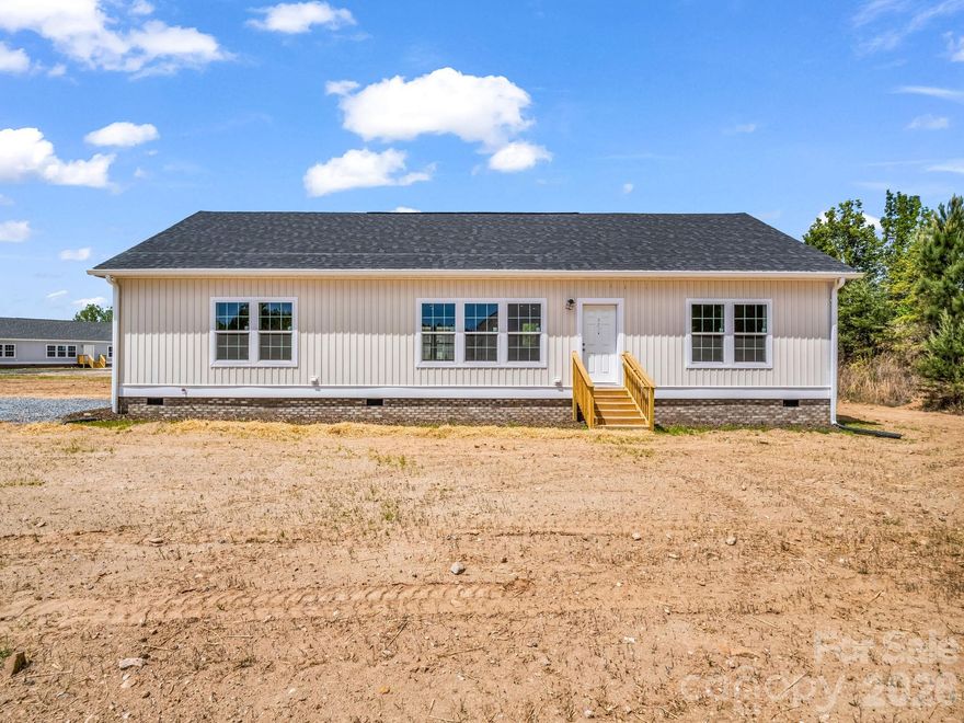 Stunning new construction - this beautifully finished 3-bedroom, 2-bath home offers modern design, quality craftsmanship, and effortless one-level living. Comfort and functionality are key features in this off-frame modular home. Inside you'll find 9 ft ceilings, 8 foot doors, crown molding, expansive windows and an open, light-filled layout.  The kitchen is a true centerpiece featuring quartz countertops, a large center island with seating and an undermount stainless steel sink, vented range hood, ample cabinetry, designer tile backsplash, matte black fixtures and all new appliances.  The spacious living area flows seamlessly into the kitchen and dining space, perfect for both everyday living and entertaining.  The primary suite offers a relaxing retreat with freestanding soaking tub, dual vanities, and a beautifully tiled walk-in shower with glass enclosure. The 2 additional bedrooms provide flexibility for family, guests or a home office. Additional highlights include low-maintenance vinyl flooring in the living areas and cozy carpet in the bedrooms, a dedicated laundry room and stylish lighting. Enjoy all the benefits of new construction-modern finishes, efficiency, and low maintenance, ready for you to move right in!   Situated along HWY 221 in Forest City, this home offers quick and easy access to major highways, making commuting a breeze and providing convenient access to both North and South Carolina.