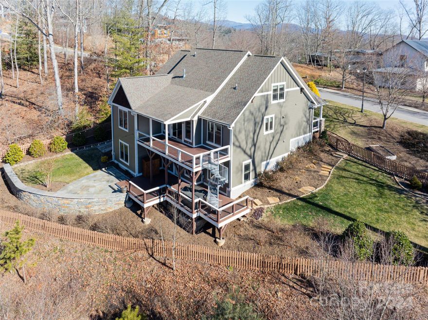 Located in Beaucatcher Heights, just minutes from downtown Asheville and historic Biltmore Village, 4 Faulkner Ave is a newer 4-bedroom home situated on a .5 acre homesite that delivers an incredible location, 4,100+ SqFt, and tremendous outdoor living space. The main level features an office, living room with cathedral ceiling and gas fireplace, large kitchen with granite tops, stainless appliance package and gas range, and a primary suite with double vanities and walk-in tile shower. The upper level has 2 guest bedrooms, a second office, and full bath. The lower level includes a family room, large rec room, gym with rubber flooring, and an en-suite guest room with a soaking tub, double vanities, and steam shower. The outdoor living space includes a large back deck, partially covered with retractable screen, with a spiral staircase leading down to a lower level deck with hot tub, flagstone patio and fenced yard. Exterior recently painted and professional landscaping by BB Barns.