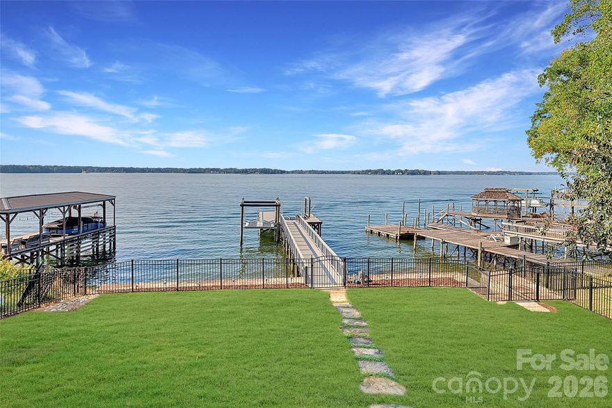 Enjoy some of the most dramatic long-range lake and sunset views Lake Norman has to offer from this exceptional waterfront home. Nestled in the highly desirable Island Forest community, this property delivers an unparalleled blend of luxury, comfort, and breathtaking natural beauty. Step inside the dramatic two-story great room, where expansive windows capture sweeping lake vistas and fill the home with natural light. The beautifully updated gourmet kitchen features high-end appliances, generous workspaces, a large island, and elegant finishes—perfect for both everyday cooking and entertaining. The fully finished lower level provides an additional living and entertaining hub, complete with a full bar, a dedicated wine room, and flexible spaces ideal for gatherings, recreation, or hosting overnight guests. Outdoors, your private lakeside retreat awaits. A fenced yard, direct access to the water, a boat lift, and a jet ski lift make lake living effortless. Spend evenings by the water’s edge, take off for sunset cruises, or simply relax and enjoy the panoramic views from your backyard.
Additional features include gleaming hardwood floors throughout the main level and 39 solar panels, offering impressive energy efficiency and long-term savings. This remarkable property is the perfect blend of luxury living, thoughtful design, and the captivating beauty of Lake Norman—an opportunity not to be missed.