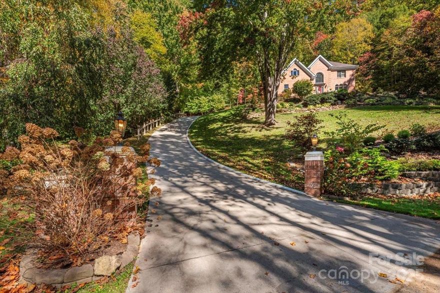 An elegant mountain residence in the Laurel Ridge Country Club community, offering year-round access, golf lifestyle amenities, and the space and comfort sought by buyers relocating to or within Western North Carolina. Whether arriving from Florida, Texas, the Northeast, Midwest, or a nearby WNC community, this home delivers a refined mountain lifestyle without sacrificing convenience or accessibility. The location provides easy access to Asheville Regional Airport, downtown Asheville, and major routes connecting Charlotte, Atlanta, and the Southeast.
A dramatic entry hall with soaring ceilings sets the tone for the spacious interior, which includes formal living and dining rooms ideal for entertaining. The chef’s kitchen is a true centerpiece, featuring a 6-burner Viking range and wall oven, Bosch refrigerator, new Viking microwave, wine cooler, walk-in pantry, oversized island with seating, breakfast nook, and abundant storage. The kitchen opens seamlessly to a warm keeping room with fireplace and custom built-ins which are perfect for everyday living or hosting guests.
Upstairs, the expansive primary suite serves as a private retreat with its own fireplace and a luxurious bath complete with spa tub. Two additional guest bedrooms and a large office provide flexibility for family, visitors, or remote work that are deal for full-time residents, second-home owners, or those transitioning to mountain living.
The landscape is professionally designed with four-season color and natural beauty. Outdoor living is designed for relaxed mountain enjoyment, featuring a private tiled patio with stainless steel Weber grill, beverage refrigerator, wood-burning oven, and sink that is well suited for entertaining during cooler summers and crisp fall evenings.
Additional highlights include a full-house water filtration system, LeafFilter gutter guards with lifetime warranty, attached two-car garage, separate golf cart garage, and workshop space for hobbies or additional storage. Located just minutes from Laurel Ridge Country Club amenities, golf, downtown Waynesville, and convenient access to Asheville and regional travel routes, this home offers an exceptional opportunity for those seeking quality mountain living in Western North Carolina.