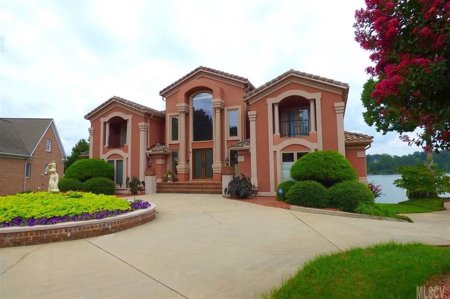This Mediterranean masterpiece will make you feel like you are on vacation year 'round! Offering panoramic views of Lake Hickory from nearly every room, this renovated executive home offers top quality finishes inside and out. The main level features a two-story foyer with curved staircase wrapped around a fountain, with decorative iron gates leading into the living room with stunning views of the lake. The expansive kitchen is any chef's dream, with professional-grade appliances and wall-to-wall views of the water. You'll also find three bedroom suites with private baths on the main level. Upstairs, the master suite retreat features a private balcony, den with fireplace, and huge bathroom with 2nd fireplace, whirlpool, tiled shower, dual vanity, dressing room, & a spectacular walk-in closet. The 2nd level also has a 5th bedroom suite, laundry, & storage. The basement offers a den, wet bar, media room, office, gym, billiards, and exit to the pool patio and outdoor fireplace & dock.