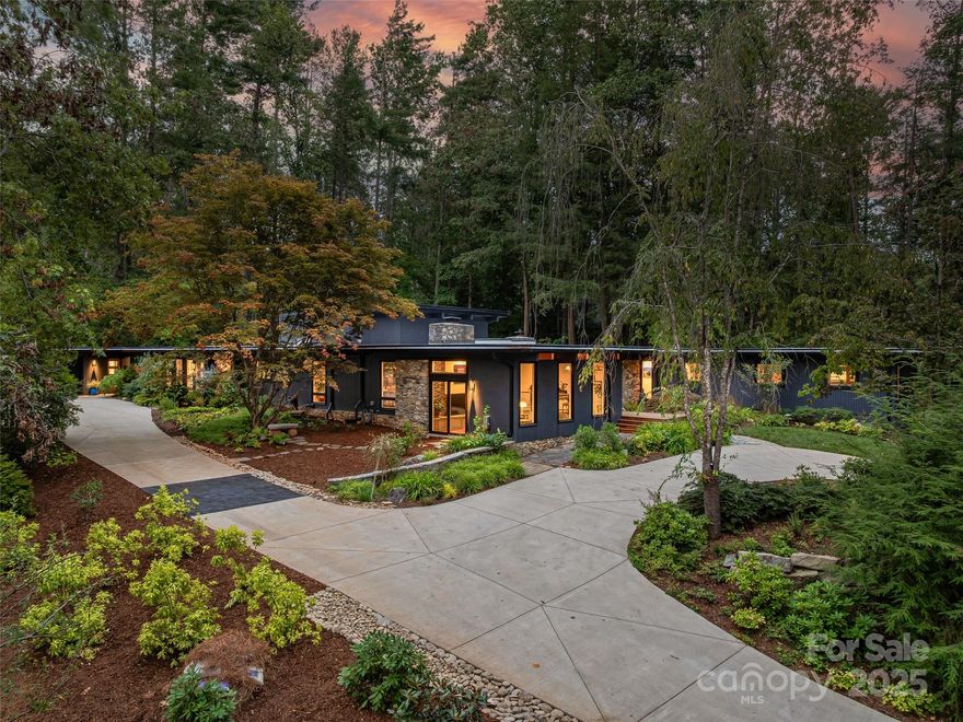 Originally built in 1966 by renowned Asheville architect Lawrence Traber, 5 Brookside is widely considered one of his finest mid-century modern works. Designed around Traber’s philosophy of harmony with nature, the home is set on 1.34 acres of lush gardens in a private, wooded setting—just minutes from downtown Asheville.
Meticulously and respectfully reimagined, the home blends iconic design with extensive high-end upgrades. Steel beam construction provides lasting structural integrity. Recent exterior improvements include fresh paint (2024), a double-thickness TPO roof with a 20-year warranty (2025), new gutters, and four new skylights that flood the interior with natural light.
Inside, the home features new Brazilian cherry hardwood floors, paneled columns, and new 8" baseboards throughout. Sierra Pacific windows enhance both aesthetics and efficiency. Comfort and reliability are ensured with a Generac whole-house generator, Rheem HVAC and heat pump system (2023) with five zones, a new air handler (2025), and a Navien high-efficiency tankless water heater with recirculating pump (2023). New sewer and water lines were installed in 2025.
The fully remodeled kitchen (2024) is a showpiece, featuring premium Fulgor appliances, a 48" stainless Sub-Zero refrigerator, and a newly added butler’s pantry. A separate laundry room with Miele appliances adds everyday convenience. A partially finished lower-level room offers flexibility for a home gym, music room, playroom, or office.
A dramatic two-story wall-of-glass Garden Room addition (2024) creates a striking connection to the outdoors and opens to an expanded back terrace. Outdoor features include a flagstone retaining wall, hidden drainage, a soapstone gardening shelf, and a welcoming stone patio ideal for entertaining.
The primary suite was fully renovated and expanded in 2025, creating a peaceful retreat with a luxurious new bath and a spacious walk-in closet with custom built-ins. Thoughtful lighting throughout highlights art and architecture, including select permanent installations with custom metal ironwork by local artisans Screaming Hot Iron.
Additional improvements include an expanded circular concrete driveway (2024) with new exterior lighting and numerous system upgrades that make this home as functional as it is beautiful.
A rare opportunity to own a thoughtfully modernized architectural landmark, 5 Brookside offers timeless mid-century design, exceptional craftsmanship, and a tranquil natural setting—just moments from the heart of Asheville.
