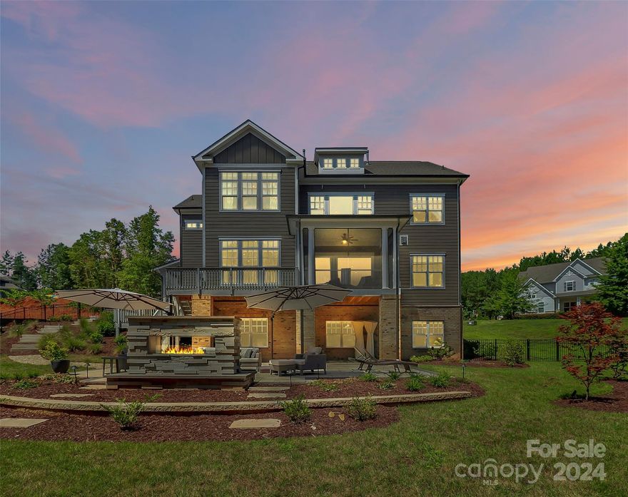 Welcome to your dream home! This John Wieland masterpiece sits on 150'+ of shoreline w/beautiful views of Lake Wylie. An open floorplan offers entry into an elegant foyer w/exquisite trim detail, dining room w/grasscloth wall covering, & home office w/leathered finish cabinetry & worktop. Chef's kitchen overlooks lake & is well equipped w/dbl ovens, abundant cabinetry, beverage fridge/bar & quartz work surfaces. Living room w/wood wrapped beams & panoramic stacking doors open to screened porch allowing you to bring the outside in. Guests may overstay their welcome in a lake view suite. Upper level primary presents beautiful wall coverings, wood beams & vaulted ceiling w/en suite & closet that dreams are made of. Each bedroom up offers a custom closet & ensuite. Walk out lower level allows you to live lake life to the fullest w/everything an entertainer would need! Large stonework patio w/stacked stone gas fireplace perfect for fall evenings. Covered dock w/lift has storage & utilities.