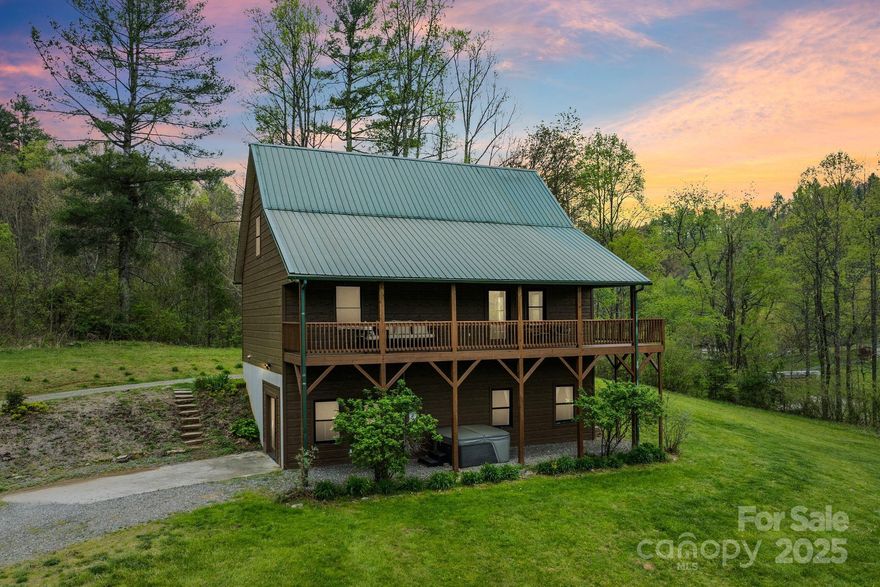 This spacious mountain retreat offers three levels of living space, perfect for entertaining while providing ample privacy. Bedrooms are thoughtfully spread out, with ensuite baths on the upper and lower levels, and a main floor bedroom with easy access to a full guest bath. The open kitchen, living, and dining areas feature abundant natural light, hardwood floors, cathedral ceilings, and tongue-and-groove woodwork, creating a warm, inviting feel. A loft overlooks the living space, and a stone gas-log fireplace adds cozy mountain charm. Step onto the expansive wraparound deck, fully covered at the front, and breathe in the fresh mountain air. The large, grassy yard offers plenty of room for outdoor fun, and the walkout basement provides a bonus room and workshop/storage area. Conveniently located 9 mins to downtown Burnsville, 25 mins to Weaverville, and 34 mins to Asheville—all that WNC has to offer is right at your fingertips. This home is ready to welcome you! Furniture negotiable!