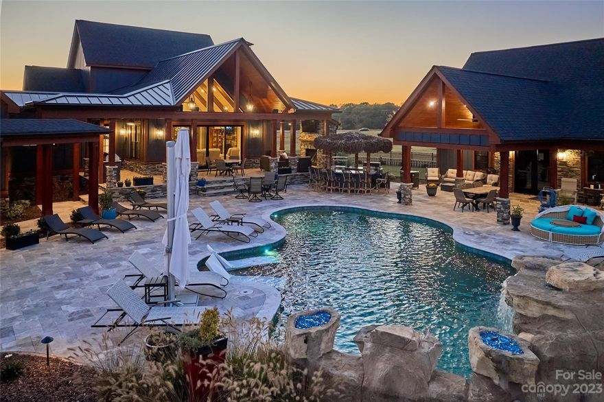 Redefines. Luxury. Living. Conveniently and privately sited on a gated 50-acre private estate. This curated home provides easy access to both Charlotte & the Tryon International Horse Park. A treasured estate, it includes: a Main Modern Farmhouse (4047’), Pool House (1498’), 7-Car Tandem Garage (2616’), 6 bay RV Garage (4155’). To note a few of the infinite amenities: vaulted ceilings with exposed beams, oak hardwood floors with walnut accents, stacked stone fireplace, chef’s kitchen extraordinaire (with top tier appliances, built-in coffee station & a hidden walk-in pantry), MonkeyPod Asia barn door entrance to private home office with built-ins, multiple Primary Ensuites, wet bar(s), 14’ sliding glass wall entrance to al fresco living, outdoor fireplace, in-ground heated &ozone treated pool (featuring a waterfall/fire rocks/travertine patio/full sound system) - and many more exclusive comforts. This marvel needs to be experienced to be appreciated. Avail yourself of the best~