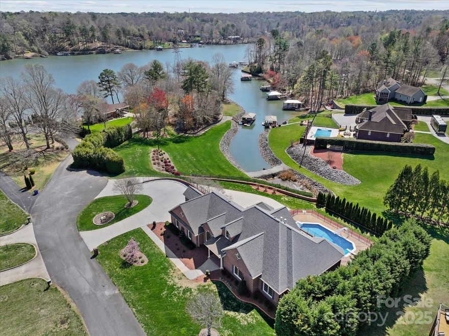 This impressive and luxurious home on Lake Hickory offers a thoughtfully distributed living space across multiple levels, providing both elegance and functionality. The main level is packed w/highlights, including a formal dining room and a great room w/stunning view. The kitchen is perfect for everyday use and entertaining, complete with double ovens, a gas range, and ample storage. Step out onto the patio off the great room to take in the scenery. You'll also find the primary suite w/a private bath, walk-in closet, & study, as well as a 2nd bedroom & bath. Practical amenities like the large laundry room & triple garage ensure comfort & convenience. The upper level features a large den, sitting area, bonus room, and bath. The full lower level is ideal for guests or extended family. A family room, bedroom, bath, full kitchen, & storage space make it incredibly versatile. The outdoor appeal is undeniable, w/a 1.66-acre double lot, in-ground pool, a covered dock, & breathtaking view!