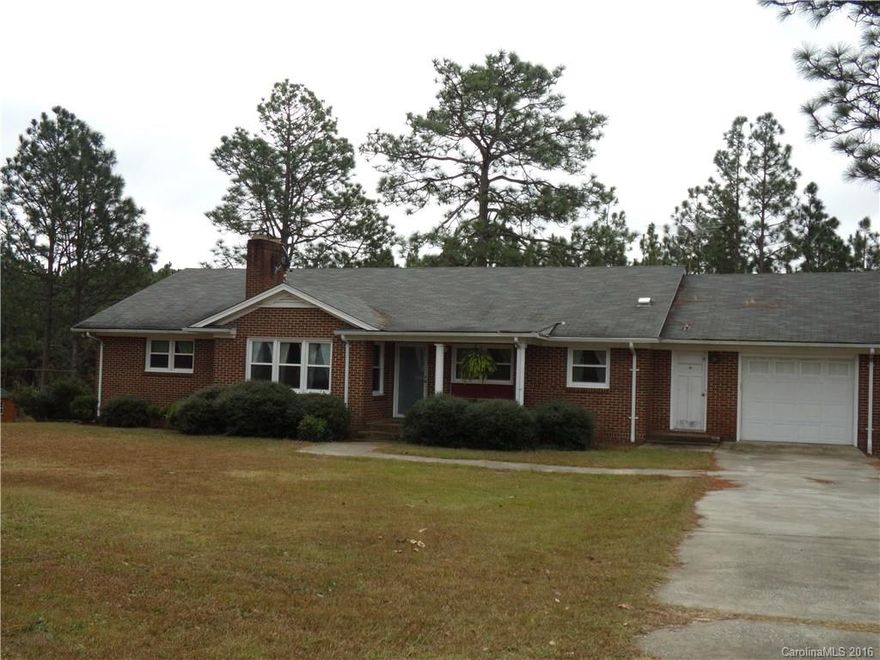 10+- ACRES with lots of paved road frontage and brick ranch with basement! Complete the renovations started on this spacious house with your own ideas! It features a large kitchen space, adjacent den/dining, LR with hardwood flooring and fireplace, three bed, two bath, one car garage, huge heated and cooled basement space with unfinished bathroom, laundry area, office space and more! Detached storage, small fenced area and lots of room to roam, among the pine trees. Year built is estimated.