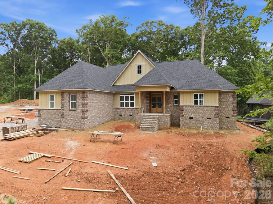 Located in the highly sought-after Country Club Hills community, this stunning new construction home offers 3 bedrooms, 3.5 bathrooms, and exceptional single-level living with upscale custom finishes throughout. The open, split-bedroom floor plan features a welcoming entry, formal dining room, and an impressive living room with soaring 20-foot vaulted ceilings and a floor-to-ceiling stone fireplace. The chef’s kitchen showcases quartz countertops, sparkling white cabinetry, tile backsplash, gas range, dishwasher, disposal, center island with microwave, walk-in pantry with custom shelving, and a bright breakfast nook. The oversized primary suite boasts a tray ceiling, custom walk-in closet, and luxurious en-suite bathroom featuring a freestanding garden tub, double vanity, & custom tile shower with standard, rainhead, and handheld shower options. Both guest bedrooms are en-suites with their own private full bathrooms. The laundry room offers quartz countertops, cabinetry, wash sink, and a convenient drop zone entry from the garage. Additional highlights include a screened rear porch, Thermal modified ash ceilings on the front and rear porches, 10-foot ceilings throughout, 8-foot interior doors, finished-in-place ¾-inch ash hardwood flooring, tile flooring in all bathrooms and laundry room, and an insulated side-load 2-car garage with insulated garage door. This home is tastefully designed and built to suit your needs!