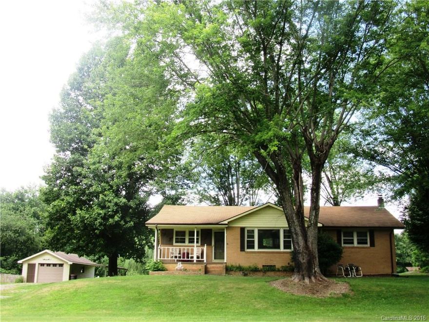 PASTORAL SETTING CLOSE TO TOWN! IDEAL ACREAGE FOR GARDEN & MINI FARM! CHARMING BRICK RANCH WITH LEVEL ACREAGE! FEATURES: KITCHEN W/ BREAKFAST BAR, DINING ROOM W/HW FLOORS, GREAT ROOM WITH LARGE PICTURE WINDOW & HW FLOORS, MASTER ON MAIN, NEUTRAL DECOR, LOTS OF STORAGE. UNFINISHED BASEMENT FOR STORAGE OR WORKSHOP. LARGE BACK DECK OVERLOOKING YARD. ATTACHED 1 CAR GARAGE, DETACHED 1 CAR GARAGE W/COVERED AREA. CLOSE TO I-26, ACCESS TO  ASHEVILLE & SC.