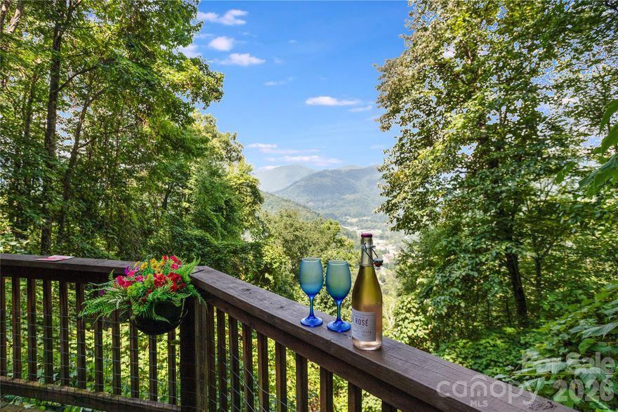 Charming Mountain Retreat Overlooking Historic Maggie Valley
Nestled in the heart of the Smoky Mountains, this 2-bedroom, 2-bath home exudes a châteaux-like ambience and offers both comfort and investment potential, along with a private, end of cul de sac setting just minutes from Soco Road and the center of Maggie Valley. The sellers have cherished this home for the past 12 years, and it is now ready for new owners to create their own mountain memories.

The main level features a light-filled living area where a wall of windows frames the mountainside and valley below.
Neutral tones expand the sense of space, while a gas log fireplace provides cozy warmth—perfect for relaxing on cool autumn evenings. The nicely appointed kitchen includes a stylish backsplash and stainless steel appliances, with a conveniently tucked laundry closet nearby. An additional refrigerator/freezer in the garage also conveys.

From the main living area, step onto the expansive deck, a stunning vantage point for outdoor dining, stargazing, or relaxing in the hot tub. Views from this special spot include Maggie Valley’s Festival Grounds (with music drifting up onsummer nights), the Wheels Through Time Motorcycle Museum, and the twinkling lights from Cataloochee Ski Center.

Upstairs, the spacious primary suite enjoys its own private bath, with a guest bedroom and full hall bath completing the level. An enclosed porch offers another inviting space for dining or relaxing on cooler days.

Designed for both everyday comfort and easy entertaining, pride of ownership is evident throughout. The sellers have carefully maintained the property and have consistently earned 5-star guest reviews on VRBO during their ownership. Most furnishings convey, with a few exclusions—please inquire for details. With its proven rental appeal and prime location just minutes from the Blue Ridge Parkway, waterfalls, hiking trails, and Cherokee Casino. This home is equally suited as an income-producing investment or a private mountain retreat. 

This is more than a home—it’s a chance to embrace the charm, history, and energy of Maggie Valley from your own mountain hidaway.