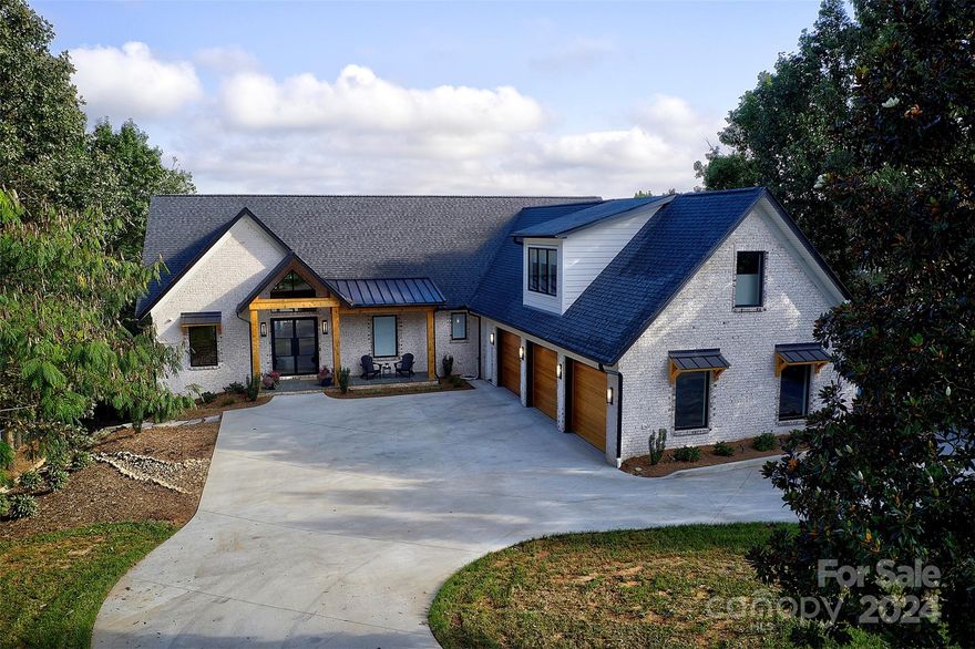 Enjoy lake life on beautiful Lake Hickory. The custom built 5 bed, 5.5 bath, luxury home is bathed in sunlight, & grabs you the moment you walk thru the front door. The beamed cathedral ceilings and wood floors add to the elegance of this home. You can't help but notice the well thought out details as you tour the home. Solid wood interior 8ft doors, 10ft wide garage doors, beautiful natural elements, w custom details. Baseboards are solid wood. Quartz countertops throughout, w an amazing kitchen, hidden pantry & induction cooktop. The expansive deck, equipped w motorized screens, fireplace, wood finished cathedral ceiling is an ideal outdoor living space. The lower level has 10 ft ceilings. Each BR has an en suite. Spacious woodworking shop on the LL. The LL has protected patio with an outdoor kitchen area. Main channel w beautiful views. Rare 5 bed septic permit. Good water depth all year long. Furnishing are negotiable & from Restoration Hardware. Pontoon is for sale also.