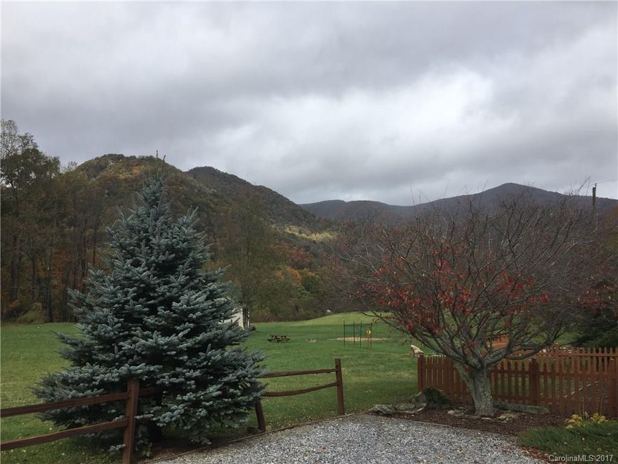 STUNNING mountain cottage located in Maggie Valley with 360' views! Like brand new! Last year brand new screen room with insulated roof in case you wanted to add a room. Front rocking porch. Elk and deer walk right up to the home! Home is an upgraded Chariot (I believe) park model with brand new washer, all appliances, dryer, built in microwave. Custom blinds. Smallcreek. $40.00 per month maintenance fee covers all lawn care, streets, property taxes on land.Seller pays ALL closing costs for both