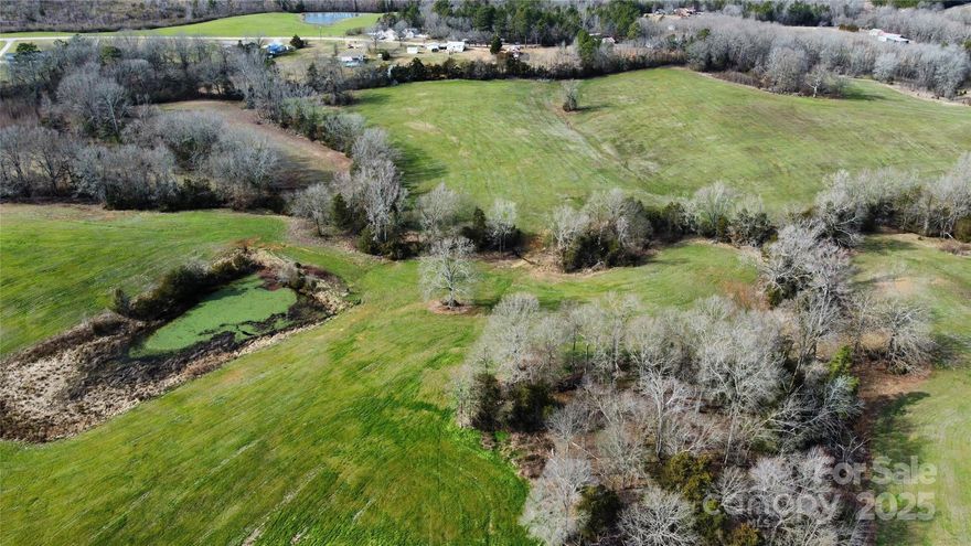 60 +/- acre portion of The Farm at Fork Hill Crossroads, a sprawling farm that seamlessly blends natural beauty with rural living. This section of the farm is mostly cultivated land with a beautiful stream dividing the property into 3 sides, the adjoining properties will be +/- 59 and +/- 27 acres each. The dividing stream eventually flows into Bakers Creek on the rear of the property and either side could be an ideal equestrian or cattle farm with development potential plus numerous stunning homesites. All 3 parcels (pending buyer paid survey & mutually agreeable boundary lines) will have road frontage to create your new entrance and driveway. The property is conveniently situated 8 miles outside of Lancaster just off of Flat Creek Rd and about an hour from either Charlotte or Columbia. This rural escape offers access to either I-77 or I-20 both about 30 miles away or head to the beaches in 3 hours. The address is not assigned, listed for GPS location only.