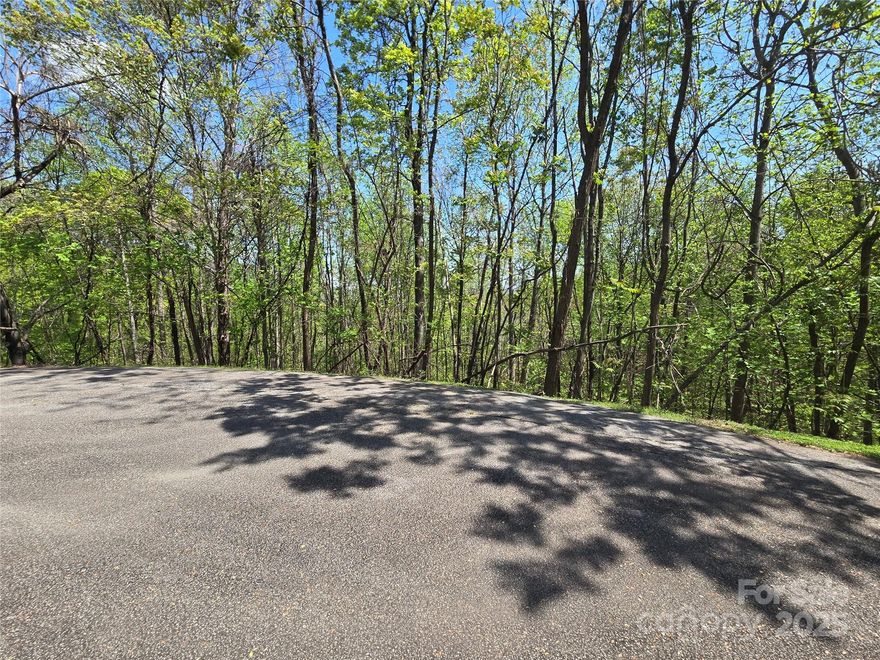 Located on the edge of a cul-de-sac, this 2.5 acre lot in the Laurel Mountain Estates section of Rumbling Bald on Lake Lure has potential for great views. The community features Underground utilities including Community Water, Power, and High-Speed Fiber Optic Internet. There are plans to add an attractive security gate to this neighborhood sometime in the future for additional privacy.  Land for a community park is in the planning stages as well. The community cart path passes through this neighborhood and provides access to the main gate via connecting paths. An amazing opportunity for anyone looking for a unique and private building site while also enjoying all the amenities Rumbling Bald has to offer including two Championship Golf Courses, three pools, Wellness Center, Spa and Salon, Beach, and much, much, more.