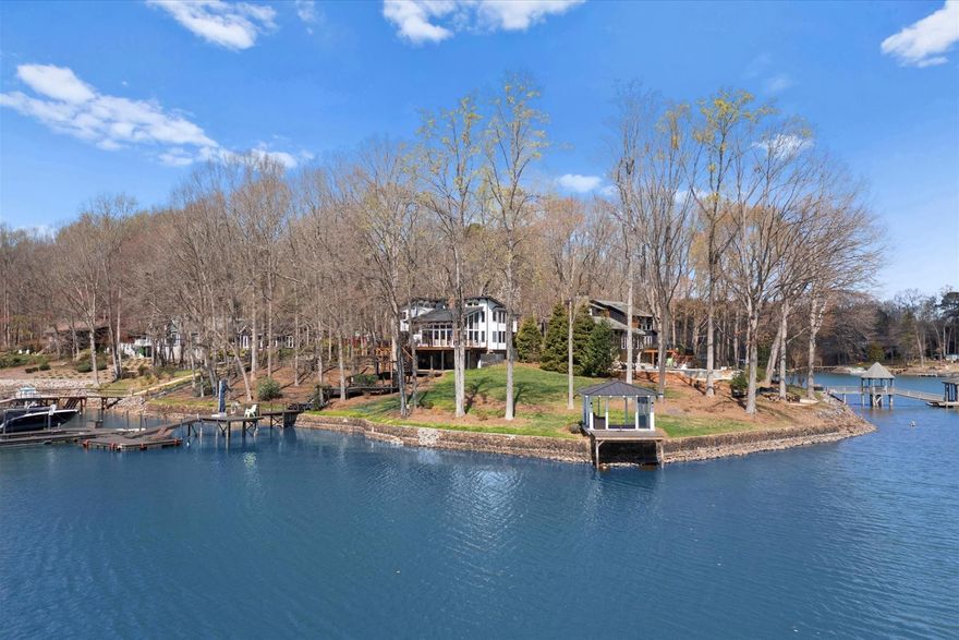 Gorgeous Highly Coveted Point Lot on Lake Norman - This property was designed so that you can see the water from every room.  It also features a "grandfathered Structure" ON the Water - New Large Custom Kitchen w/ Induction Range, New Roof, New Exterior Paint, New HVAC, New Custom Glass Hand Rail on Stairs Climbing wall to Kids Bunk Loft Area,  Basement Level has a 2nd Kitchen with ability to be a Separate guest suite/ living Area - Tons of "Intrinsic Value" with this property... Private Gate at Driveway Entrance anyone familiar with waterfront living on any lake understands the Value of a true Point Lot and this one is Spectacular.