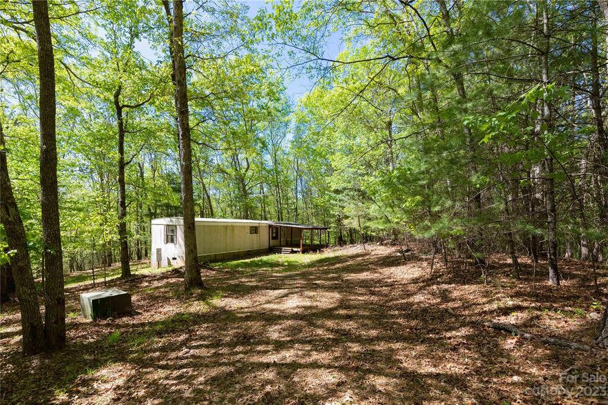 Beautiful 4.16 acre property in northern Buncombe County, adjoining the Sandy Mush Game Lands. Large wooded area with abundant wildlife and mountain views, perfect for an outdoor adventurist. 2/1 Singlewide manufactured home on foundation; title has not been retired. Large covered front porch, open floorplan living room and kitchen. 3 bedroom septic, shared well and electric. This is the ideal location for outdoor enthusiasts; property adjoins the Sandy Mush Game Lands, 2,765 acres of land open to the public for hiking, biking, fishing, hunting and birding. Just 30 minutes from downtown Asheville and Weaverville, 20 minutes to Marshall. Also listed with adjacent 4.16 acre property, see MLS # 4025632. Adjacent property listed separately as single family residence, MLS# 4025631.