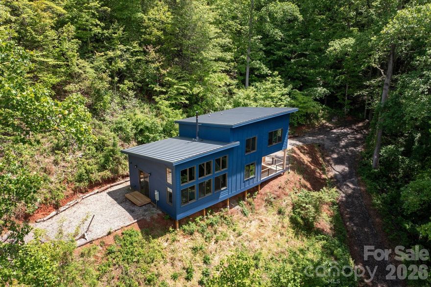 Spectacular winter long range mountain views are now visible from the main house!! This unique 7.66-ac lot borders Sandy Mush Game Lands and includes a second build site with long range mountain views, driveway, electric, and individual well/septic in place. Meticulously designed to bring the outside in, large picture windows bathe this home in natural light. Solid oak floors and wood ceilings anchor the quality of finishes throughout. Stay cozy year-round with a centralized wood-burning stove. Unwind on the covered front porch or back patio with firepit. Enjoy foraging for raspberries/blackberries.  Hike out your door to over 200 acres of national forest. Form meets function with solar ready roof, double wall insulation, and sealed, climate controlled crawlspace. Appliances included and furnishings are negotiable making this cabin move-in ready. 5 min to Grateful Roots Market, Longleaf or Addison Farms Vineyards. $20k credit at closing with acceptable offer toward minisplit installation to bring central air into the home.